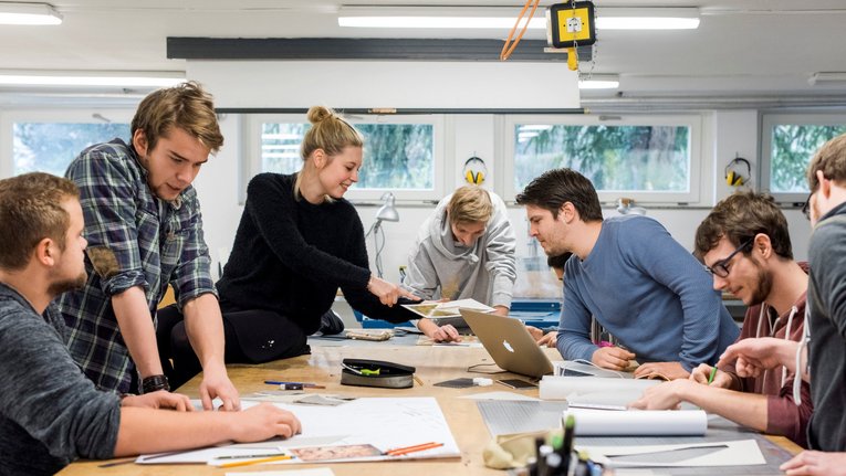 Studierende mit Unterlagen in einem Seminarraum