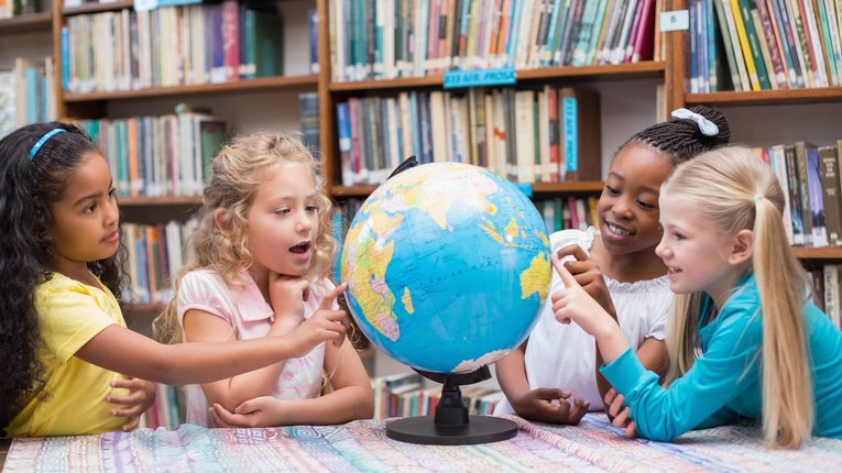 4 Kinder schauen sich einen Globus an