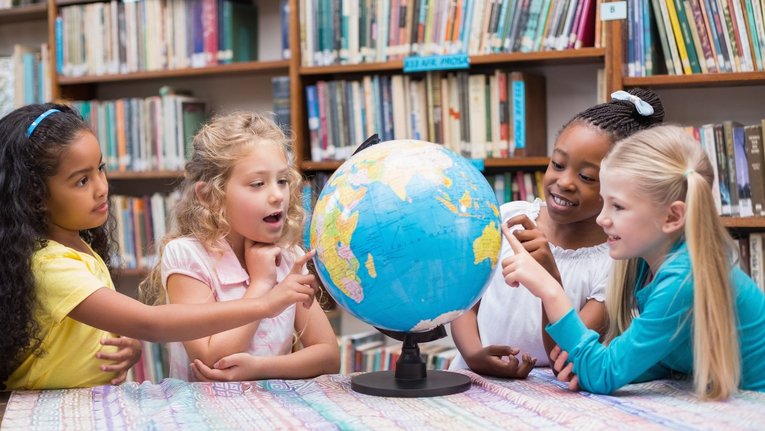 4 Kinder schauen sich einen Globus an