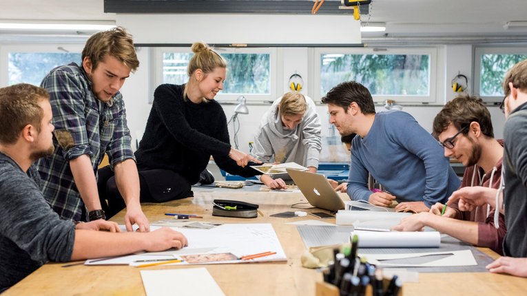 Studierende mit Unterlagen in einem Seminarraum