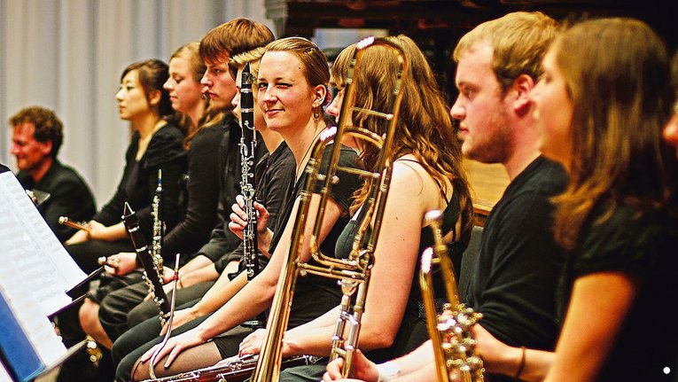 Musiker und Musikerinnen mit Blasinstrumenten