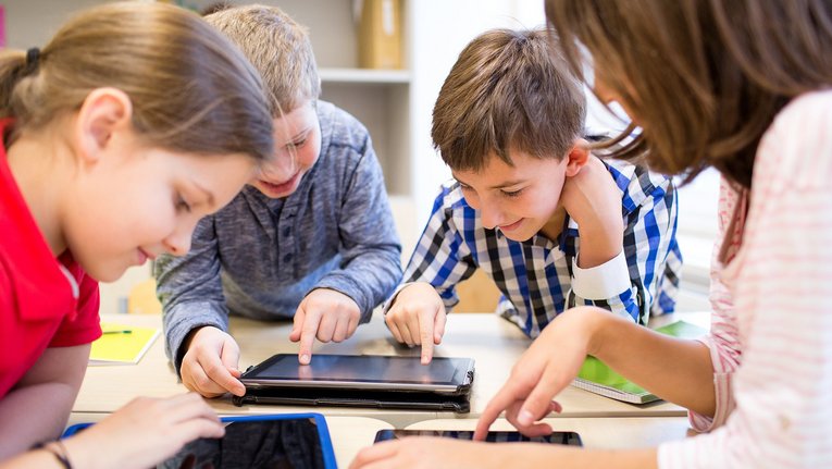 Schülerinnne und Schüler mit Tablets im Klassenraum