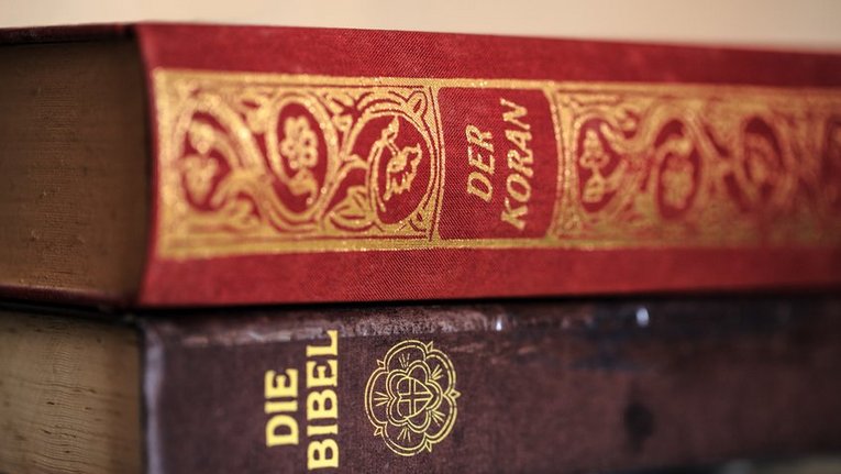 Die Bibel und der Koran aufeinander liegend