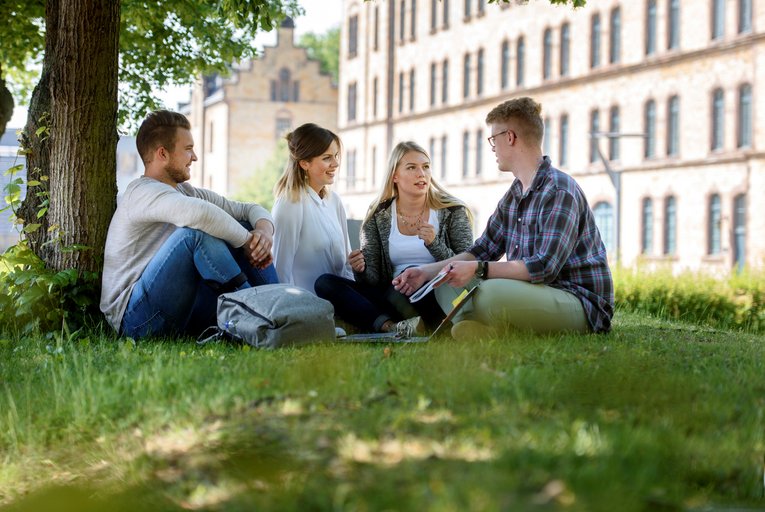 Studierende auf dem Rasen vor dem Caprivi-Campus der Hochschule Osnabrück